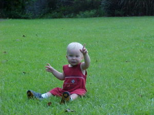 child playing in grass