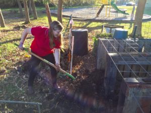 woman turning the compost pile