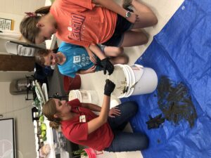 Kids helping woman with bucket