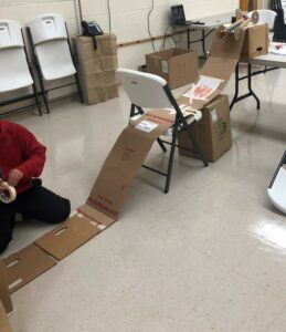 children building a cardboard racetrack