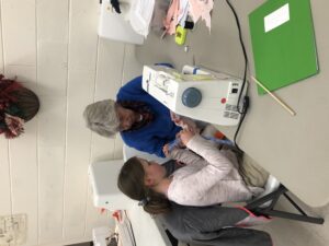 volunteer teaching a 4-her to sew