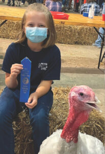 Blue ribbon winning child with a turkey