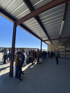 Students stand under a barn in an orchard.