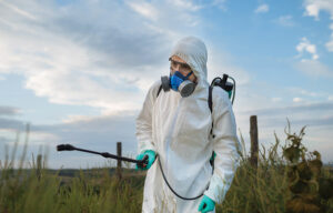 picture of pesticide applicator spraying wearing PPE