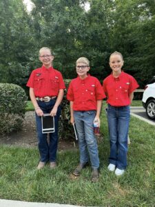 Three 4-h'ers in red shirts and jeans.