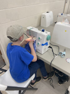 A child works at a sewing machine
