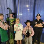 children in halloween costumes with rabbits (barista, witch, doctor, farmer, fireman)