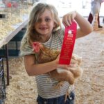child with chicken and ribbon