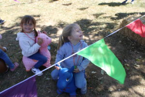 Two children stand beside a tents rope.