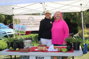 Two women pose at a table for the Bountiful harvest Community Garden