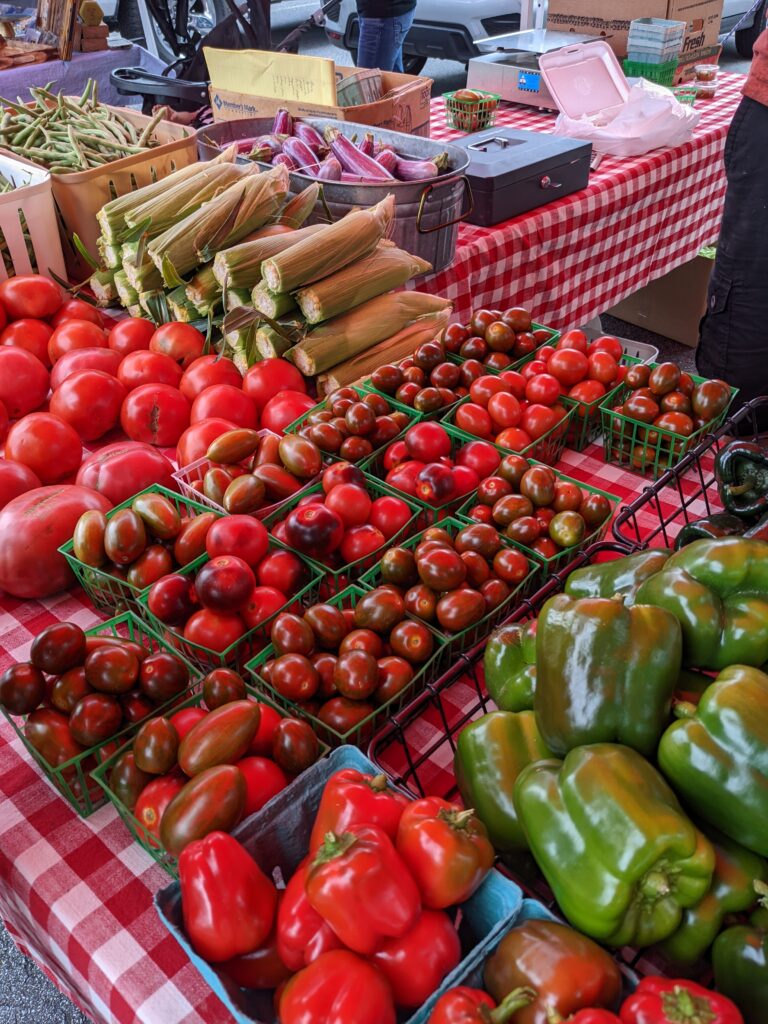 Fresh tomatoes and peppers at a farmers market.