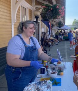 Betsy Hooker serving samples at the farmer's market.